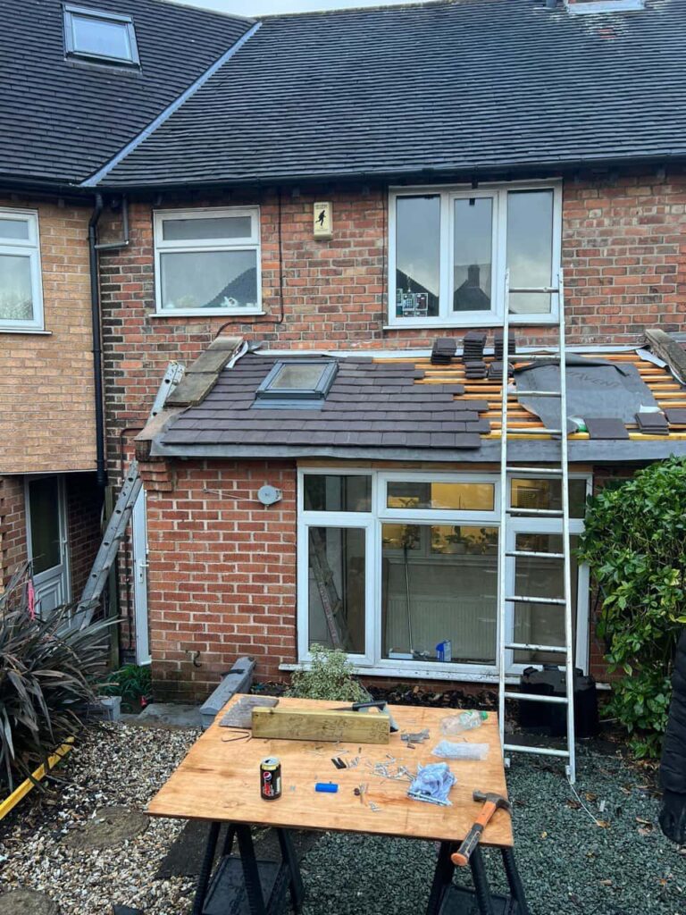 This is a photo of a roof extension that is having new roof tiles installed. This is a photo taken from the roof ridge looking down a tiled pitched roof on to a flat roof. Works carried out by Hayling Island Roofing Repairs