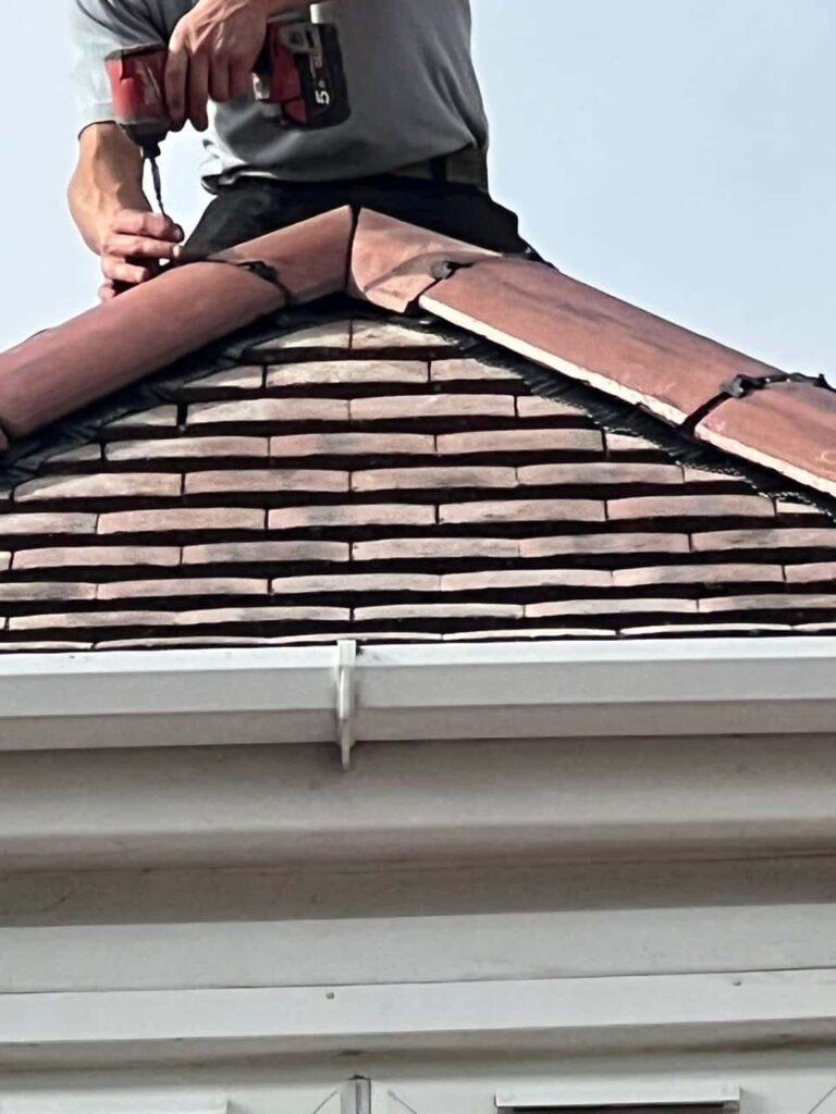 This is a photo of one of the operatives of Hayling Island Roofing Repairs installing new ridge tiles